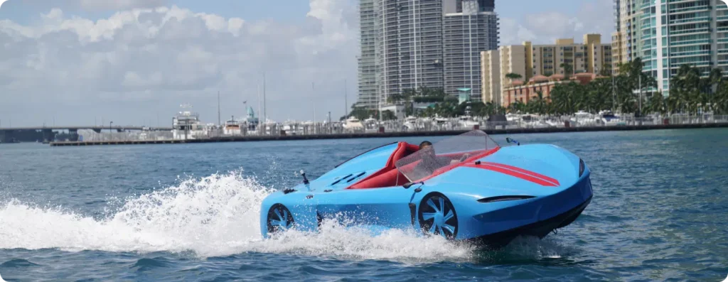 Light Blue luxury watersports car, two seats, speed boat, riding the waves. Series I with a man enjoying the ride. Available at Pier One Yacht Sales